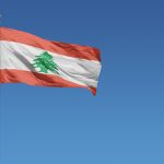 Flag of Lebanon in front of a clear blue sky