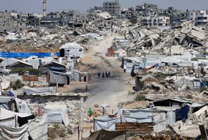 People walk at a site destroyed during the Israeli offensive, in Beit Lahiya