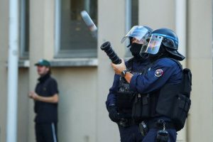 Un policía antidisturbios dispara un arma durante una manifestación estudiantil en Lyon, Francia.