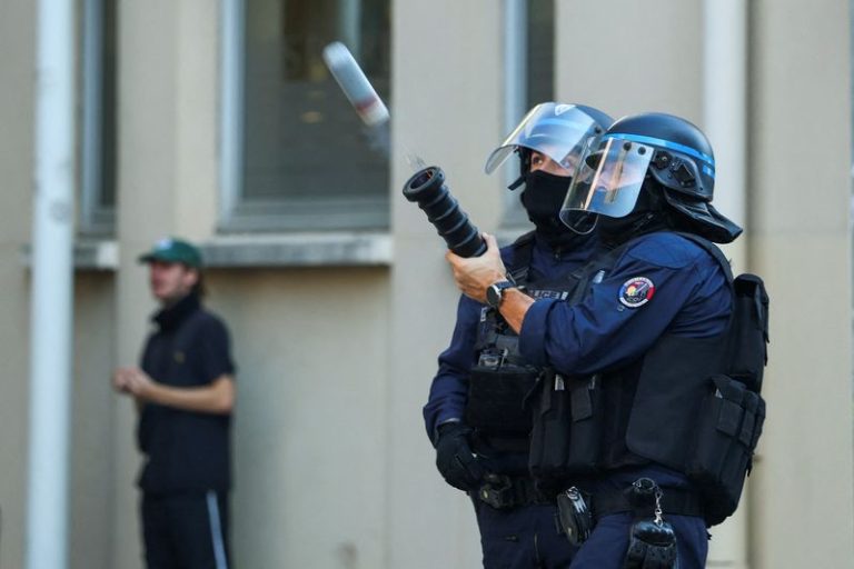 Un policía antidisturbios dispara un arma durante una manifestación estudiantil en Lyon, Francia.